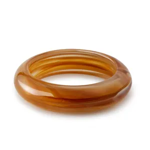Macro shot of bohemian resin bangle featuring rich amber marble texture and thick round design