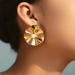 Nahaufnahme von Vintage Gold Ohrringen mit Faltenblumen und Perlen am Modellohr