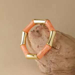 Dettaglio del bracciale in acrilico ambrato con giunture in metallo dorato su pietra