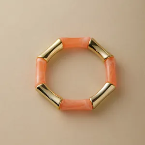 Dettaglio ravvicinato delle sezioni in resina corallo e oro stile bambù sul bracciale