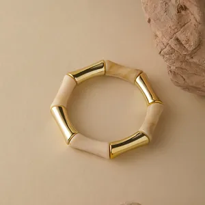 Dettaglio del bracciale stile bambù con segmenti in metallo dorato e resina crema
