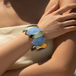 Close-up of blue marble acrylic and gold link bracelet worn on a model's wrist