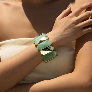 Detail of chunky green resin and polished gold metal links on a female wrist