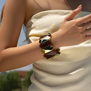 Bohemian acrylic amber and gold metal wide cuff bracelet on model in natural light