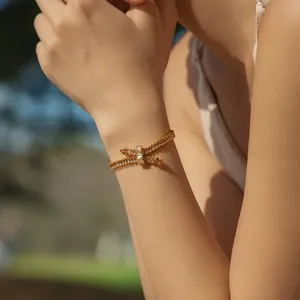 Detail of bohemian gold snake bracelet with zircon inlay worn on wrist