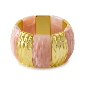 Vue détaillée du bracelet en résine marbrée rose et métal doré avec relief losange