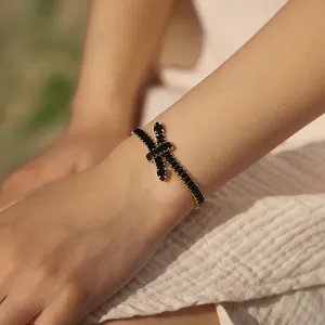 Detailed close-up of bohemian gold bracelet with black cubic zirconia knot design