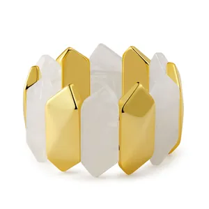 Detailed close-up of geometric acrylic bangle with gold metal pillars and white resin
