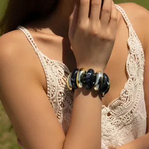 Detail showing elastic beaded bracelet with gold metal and marble resin accent beads