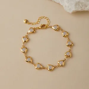Close-up of golden heart bracelet with ivory resin inlay and adjustable lobster clasp