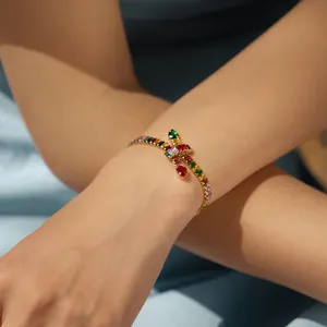 Detail of 18K gold bohemian bracelet featuring colorful zircon stones and center knot