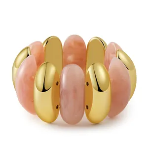 Détails de perles en résine marbrée rose et pièces en métal doré sur le bracelet