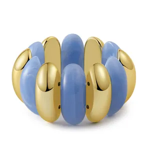 Detail of bohemian stretch bracelet with gold metal and sky blue resin oval beads