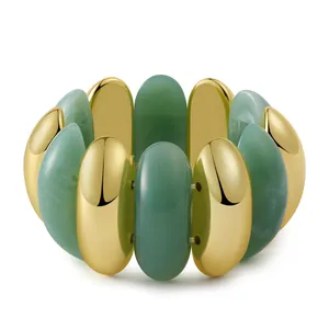 Detail of green resin and gold-tone beads on a stretch bracelet with glossy texture