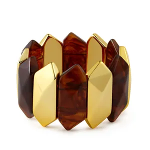 Detail of faceted gold metal and tortoiseshell resin beads on an elastic bracelet