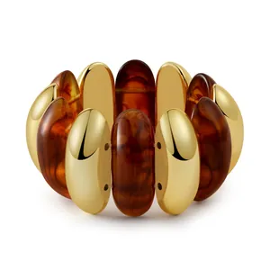 Detail of bohemian stretch bracelet with gold-plated metal and amber resin segments