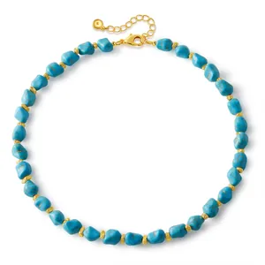 Détail macro de perles de turquoise avec séparateurs dorés et fermoir mousqueton réglable