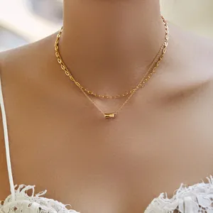 Close-up of a double-layered 18K gold plated paperclip chain with a cylinder pendant