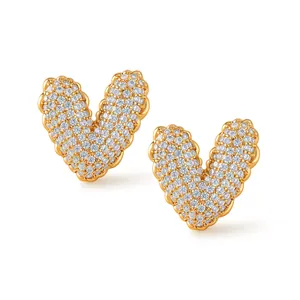 Close-up of gold V-shaped heart earrings with micro-paved zircons and bubble edge detail