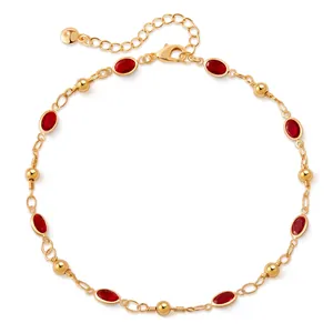 Detail of gold-plated anklet featuring red teardrop glass stones and lobster clasp