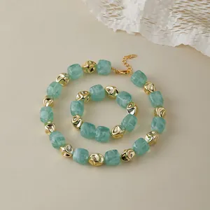 Dettaglio del set gioielli con perle in resina verde marmo e metallo dorato irregolare