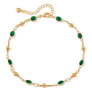 Detail of 18K gold-plated anklet featuring green oval gemstones and beaded accents