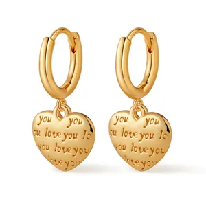 Detailed view of gold hoop earrings featuring heart charms with you love you engraving