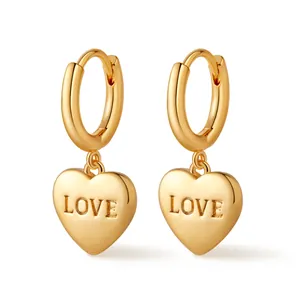 Detailed view of golden hoop earrings with heart charms featuring LOVE embossed lettering