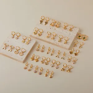 Collection of golden hoop earrings featuring starfish shell and turtle charms with zircons