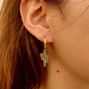 Golden cactus hoop earrings with green and red crystals shown on model's ear