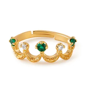 Close-up of golden crown ring featuring green zircons and adjustable open band