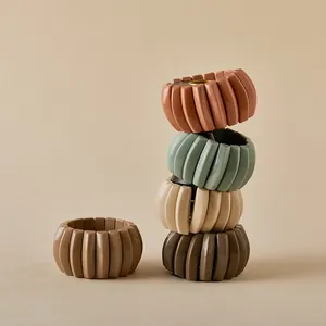 Detalle de pulseras elásticas de acordeón en cinco tonos tierra hechas de acrílico pulido