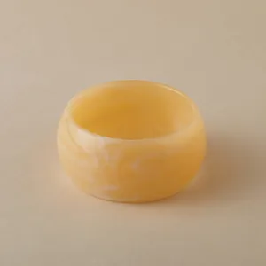 Détail d'un large bracelet en acrylique avec motif marbré beige et texture lisse