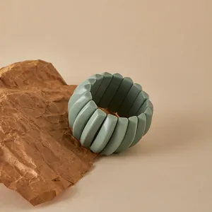 Detalle de una pulsera elástica modular verde mate con triángulos geométricos