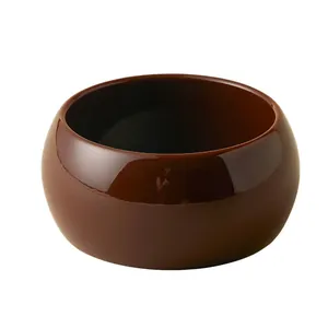 Close-up of a wide glossy amber acrylic geometric bangle with smooth curved surface