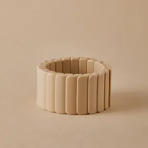 Détail d'un large bracelet élastique en résine beige mat avec des maillons rectangulaires