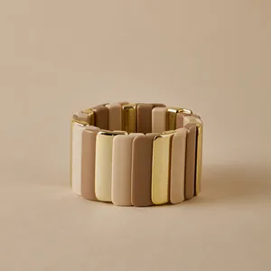Gros plan détaillé du bracelet élastique bohème avec des modules en résine dorés et tons terre