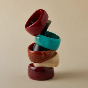 Close-up of stacked colorful acrylic resin bangles with glossy finish and marble texture