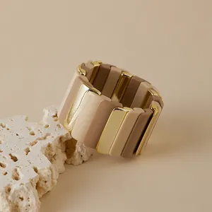 Détail d'un bracelet extensible bohème avec plaques en résine et maillons dorés brillants