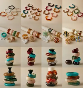 Varietà di bracciali e anelli in resina acrilica con motivi tartarugati, ambra e smeraldo