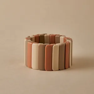 Détail macro du bracelet élastique à tuiles avec blocs de résine bohème aux tons terre
