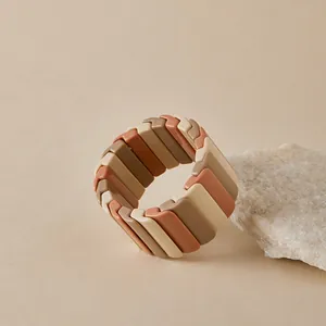 Détail d'un bracelet élastique bohème avec des carreaux en résine multicolores tons terre