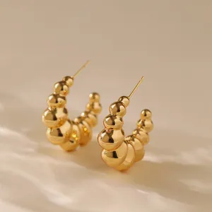 Detailed view of C-shaped bubble bead hoop earrings in polished 18K gold plated metal