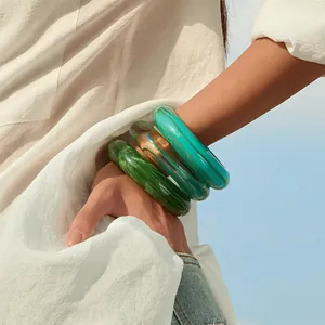 Three-piece set of thick acrylic resin bangles with marble and amber textures on model