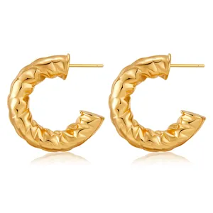 Detail of 18K gold plated C-shape earrings with a unique hammered lava texture finish