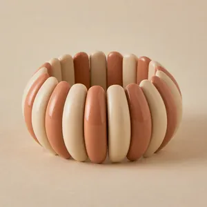 Detail of macaron resin chunky elastic bracelet featuring beige and brick red smooth blocks