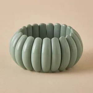 Detail of gray-green chunky resin beaded bracelet with smooth matte finish elastic band