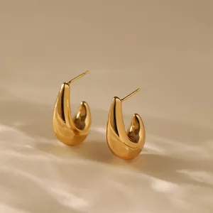 Macro view of gold-plated irregular C-shape earrings with polished mirror finish