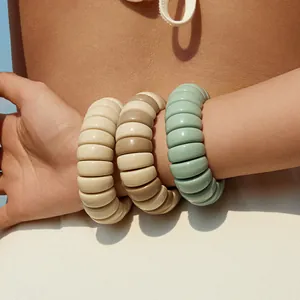 Macro shot of chunky macaron resin bangles in beige, coffee, and mint green