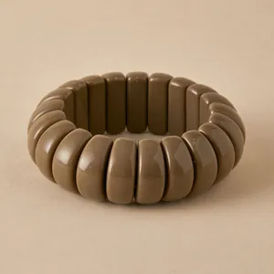 Macro shot of wide brown resin beaded bracelet with glossy curved rectangular links